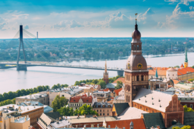 Panoramic view of the Old Town in Riga, Latvia, with the Daugava River and Vanšu Bridge in the background, showcasing the historic charm of the cityscape