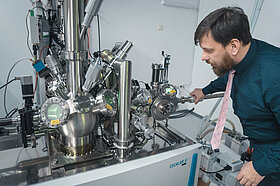 A researcher standing next to to the X-ray photoelectron spectroscopy (XPS) facility